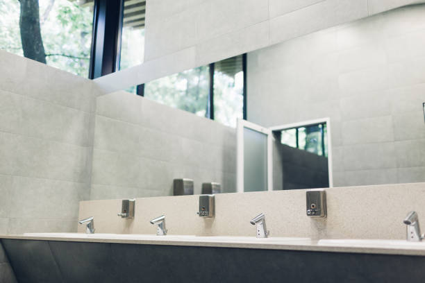 istock Modern interior design in public toilet. New sinks, taps with mirror and window above 1152255295