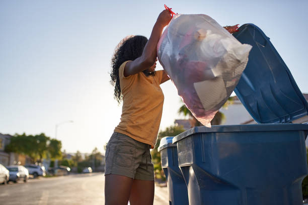 african american woman taking out the trash in las vegas neighborhood african american woman taking out the trash in las vegas neighborhood during the day garbage bag stock pictures, royalty-free photos & images