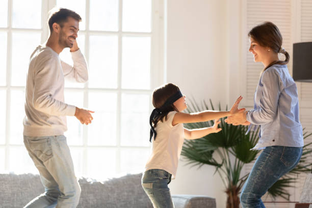 istock Blindfolded daughter and parents playing hide and seek at home 1152258008