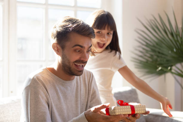 istock Happy father surprised by little adorable daughter unexpected gift 1152258022