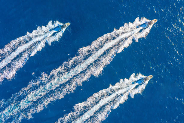 three speed boats launch at high speed floats in the ocean, aerial top view. - motorboat nautical vessel speedboat speed imagens e fotografias de stock