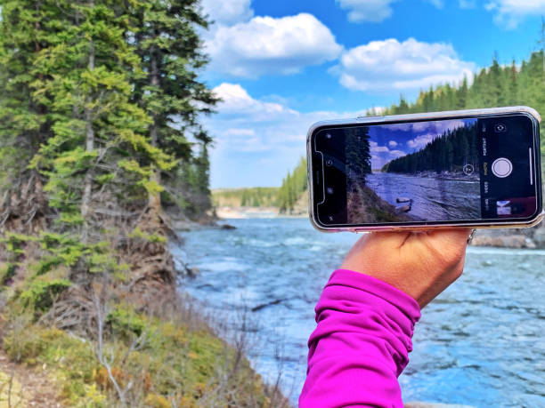 Photographing the Elbow River near Bragg Creek with an iPhone 8 Plus Bragg Creek, Alberta, Canada - May 26, 2019: Close-up of a female hand taking a picture  with an iPhone 8 Plus of the Elbow River in Kananaskis Country. iphone 8 stock pictures, royalty-free photos & images