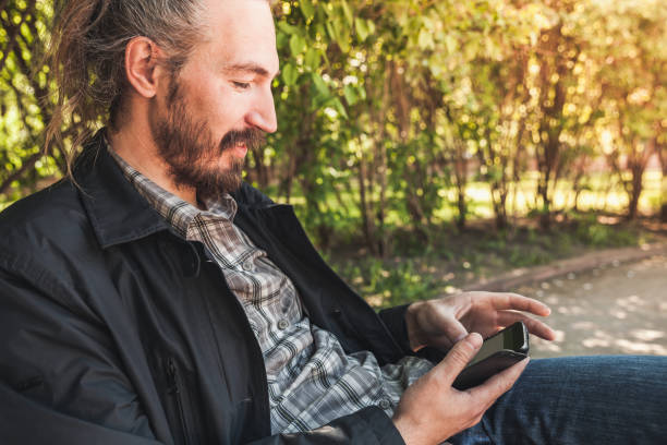 istock Young smiling man with a smartphone 1152260859
