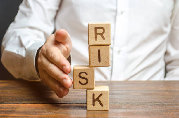 istock A man straightens a segment in an unstable tower of cubes labeled Risk. Risk management, cost assessment, and business and investment safety. Strengthen business resilience and flexibility. 1152262688