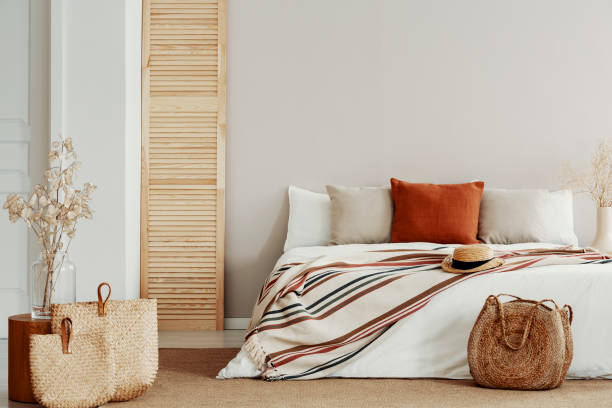 Natural bright bedroom with autumn accents, copy space on white empty wall
