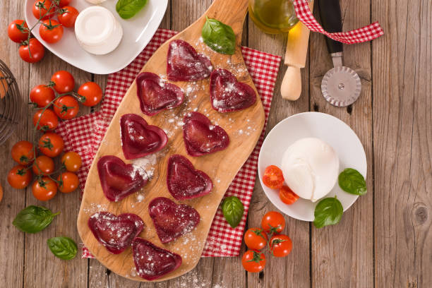 istock Red heart ravioli with tomato, mozzarella and basil. 1152264302