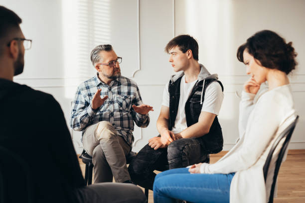 istock Psychologist talking about twelve-step program to addicted man during group support meeting 1152266969