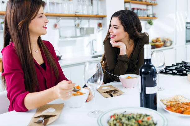 istock Two beautiful young women eating vegetables soup in the kitchen. 1152268400