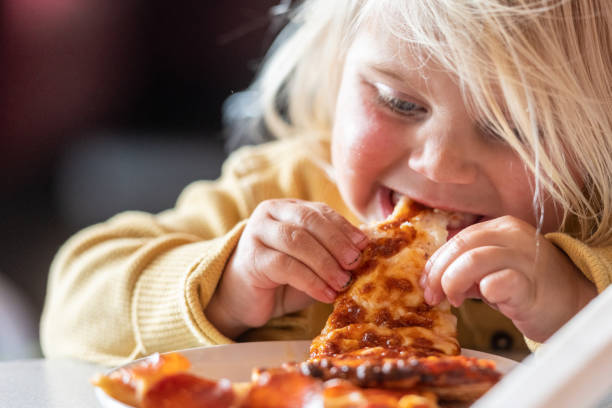 istock Little child girl having pizza 1152268455