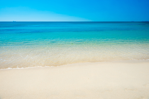 Beautiful horizon view of tropical sea and sand beach under blue sky