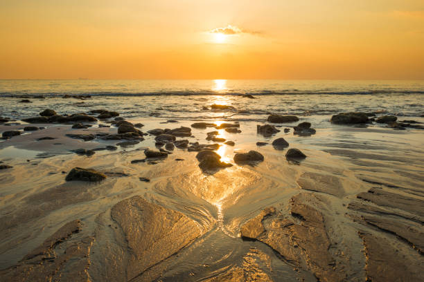 istock Sunset landscape with beach, sun and stones at sea shore 1152268731