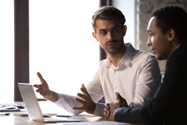 istock Diverse office workers sitting at workplace discussing working moments 1152268804