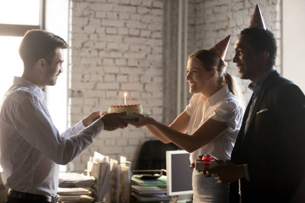 istock Diverse colleagues congratulating workmate with birthday giving cake with candle 1152268866