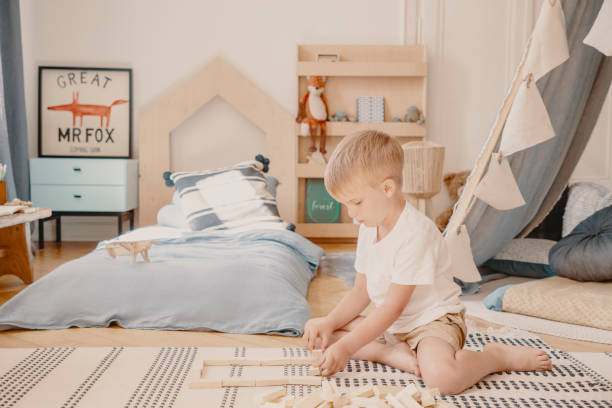 istock Young boy playing with wooden blocks in a kid room interior 1152268887