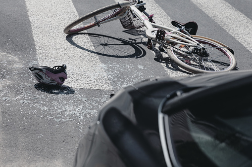 Helmet next to bike on crosswalk after collision with car