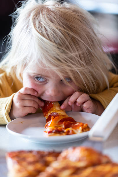 istock Little child girl having pizza 1152270585