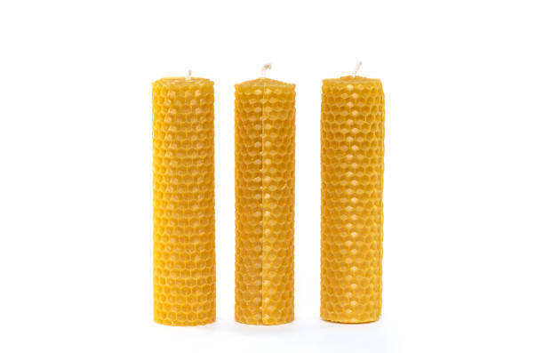 Three wax Candles with wax Honeycombs isolated on white Background