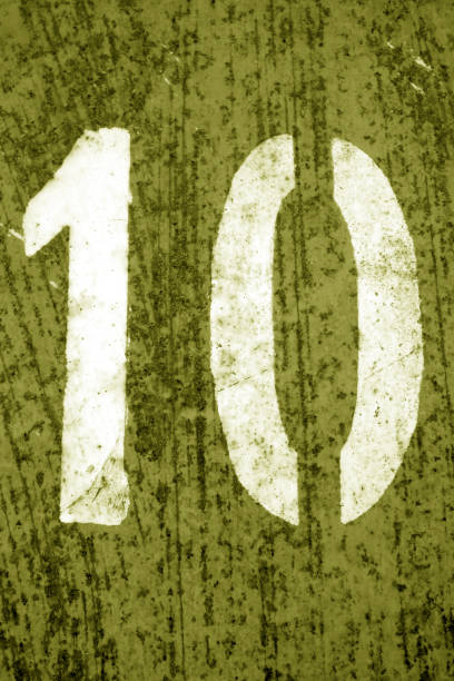 istock Number 10 in stencil on metal wall in yellow tone. 1152273469