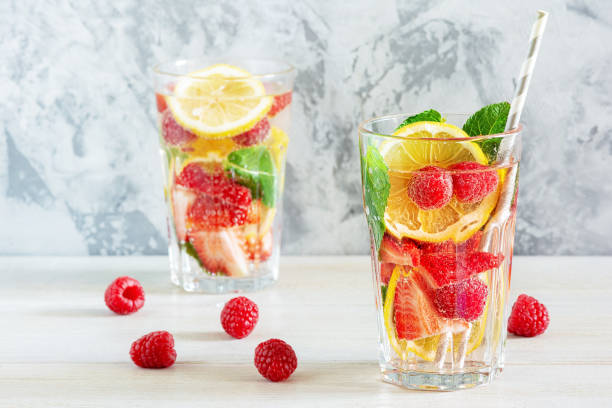 istock Refreshing summer drinks. Lemonade with berries, mint and lemon. Two tall glasses. Bright photo with space for text. 1152279468