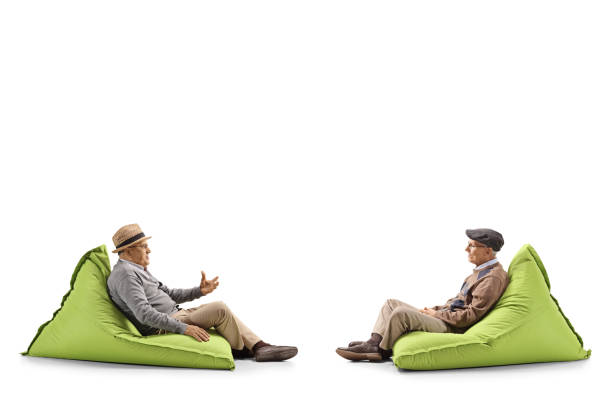 istock Two seniors talking and sitting on green bean bags 1152281158