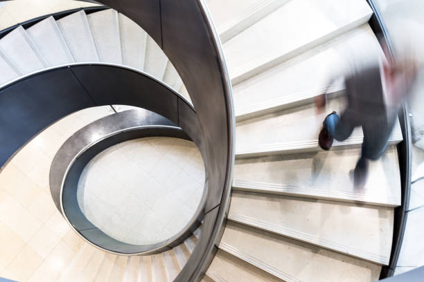 istock Blurred Motion of Man on Abstract Spiral Staircase 1152281440