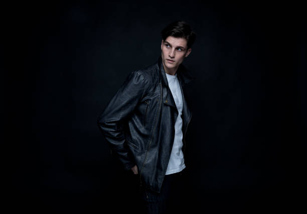 istock Good looking man wearing a leather jacket in front of black background 1152282357