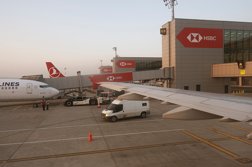 New Airport Terminal in Istanbul.\nAircraft of Turkish airlines is served by the airport team at  New International Istanbul Airport.Turkish Airlines aircraft prepare for flight from airport and authorized airport staff taking the luggage in the airplane.