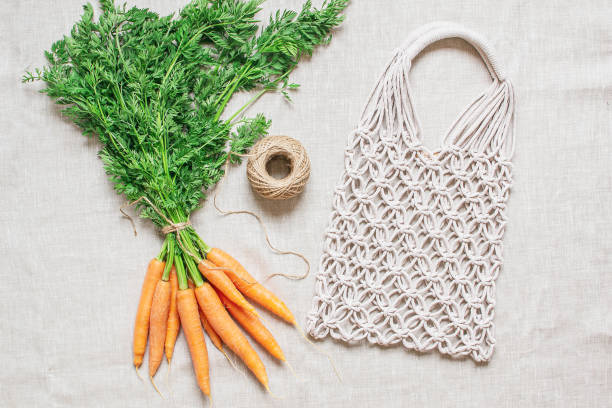 istock Handmade macrame bag with fresh carrots on the linen background, ECO friendly. Embroidery. Modern summer concept 1152282775