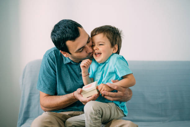 istock Cute boy surprising his father with a gift for Father's Day 1152283682