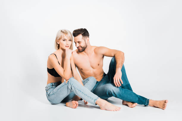 novio guapo y hermosa novia posando en ropa interior y jeans en gris - shirtless jeans women blond hair fotografías e imágenes de stock