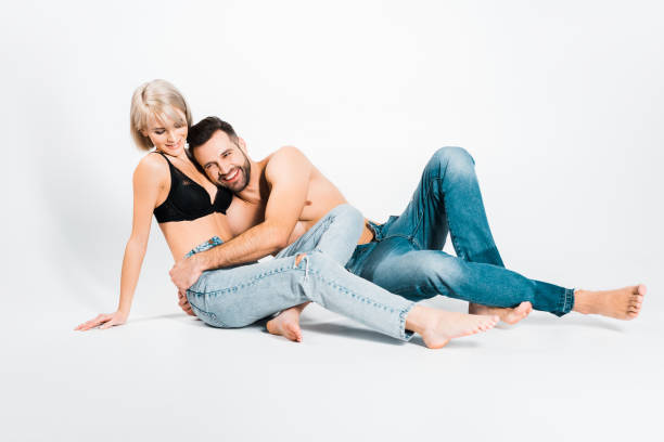 hombre y mujer posando en ropa interior y jeans en gris - shirtless jeans women blond hair fotografías e imágenes de stock