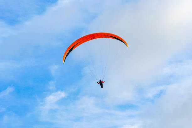 Man doing sport (Para-glider). Man paragliding in the clouded sky. Paragliding is an extreme sport and recreation. Torrey Pines Glider port. San Diego. California, USA.