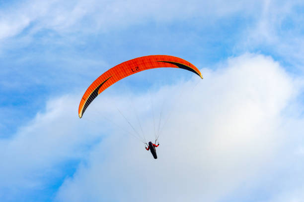 Man doing sport (Para-glider). Man paragliding in the clouded sky. Paragliding is an extreme sport and recreation. Torrey Pines Glider port. San Diego. California, USA.