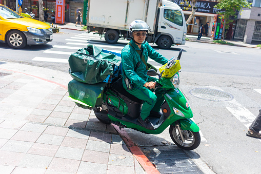 Taipei, Taiwan - May 5, 2019: Postman on an electric motor bike in Taipei