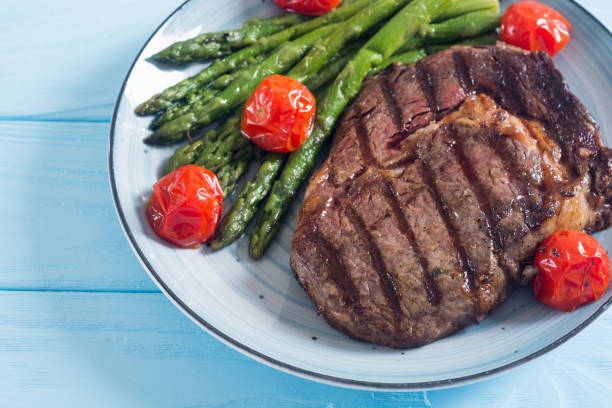 istock Grilled beef steak ribeye with cherry tomatoes and asparagus 1152303446