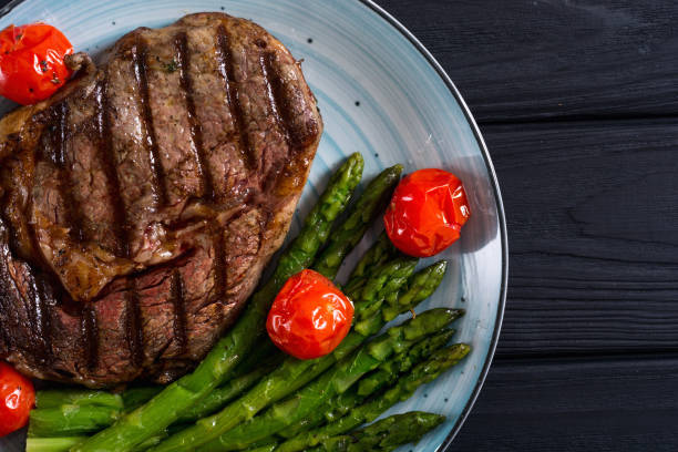 istock Grilled beef steak ribeye with cherry tomatoes and asparagus 1152303460