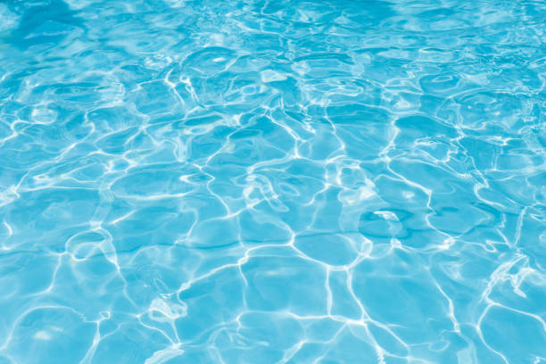 istock Abstract of blue water surface in swimming pool, Ripple wave in pool with sun reflection 1152307417