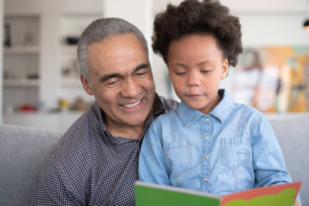 istock Black Grandpa Reading With Granddaughter 1152310124