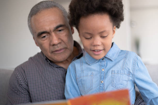 istock Black Grandpa Reading With Granddaughter 1152310127