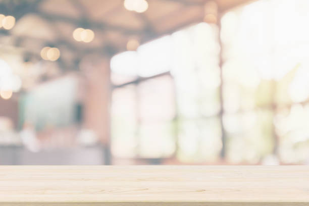 istock Empty wooden table top with cafe restaurant or coffee shop window interior abstract blur defocused with bokeh light background for montage product display 1152310287