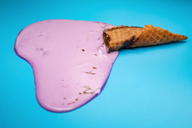 istock side view lilac ice cream cone melting on blue background 1152316220
