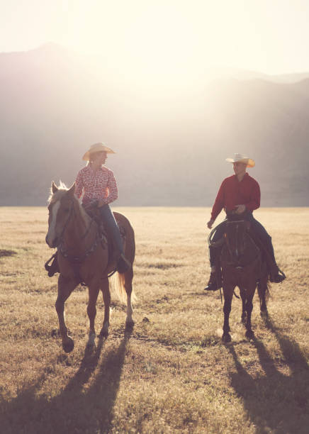 istock Ranchers couple horseback riding at sunrise 1152317391