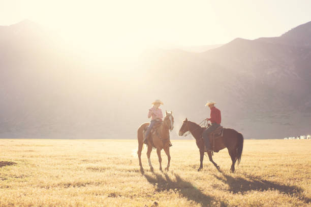 istock Ranchers couple horseback riding at sunrise 1152317433