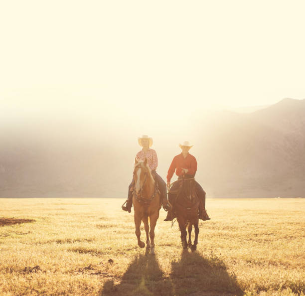 istock Ranchers couple horseback riding at sunrise 1152318307