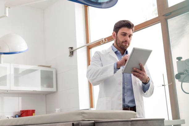 Veterinary doctor using digital tablet while standing at clinic stock photo