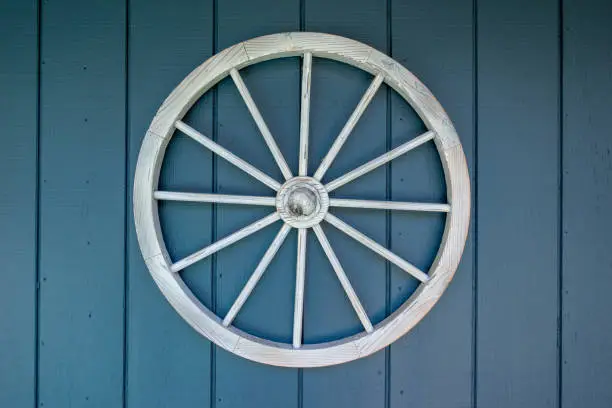 White wagon wheel hanging on blue wall