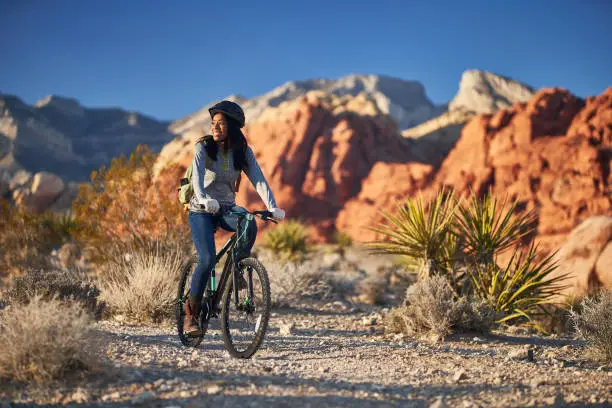 fit african american woman riding bicycle offroad in red rock canyon park during the day