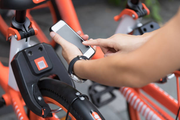 manos usando smartphone escaneando el código qr de la bici compartida en la ciudad - bikeshare fotografías e imágenes de stock