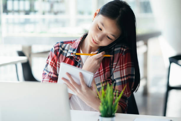 istock Young office woman talking on mobile phone with client. 1152329675