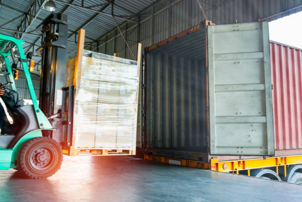 Warehouse and Logistics shipping with container Forklift driver unloading shipment product pallet into container bkk stock pictures, royalty-free photos & images
